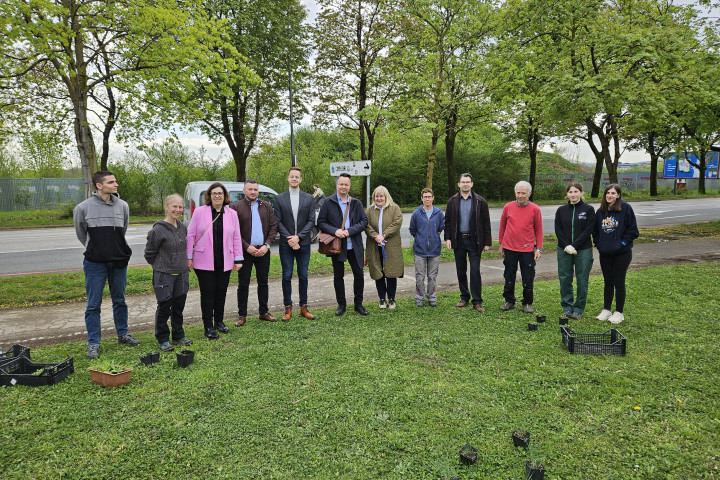 Slika udeležencev in predstavnikov vodstva Pedagoške fakultete na zelenici pred UL PEF ob dogodku zasaditve zelenice z medovitimi rastlinami