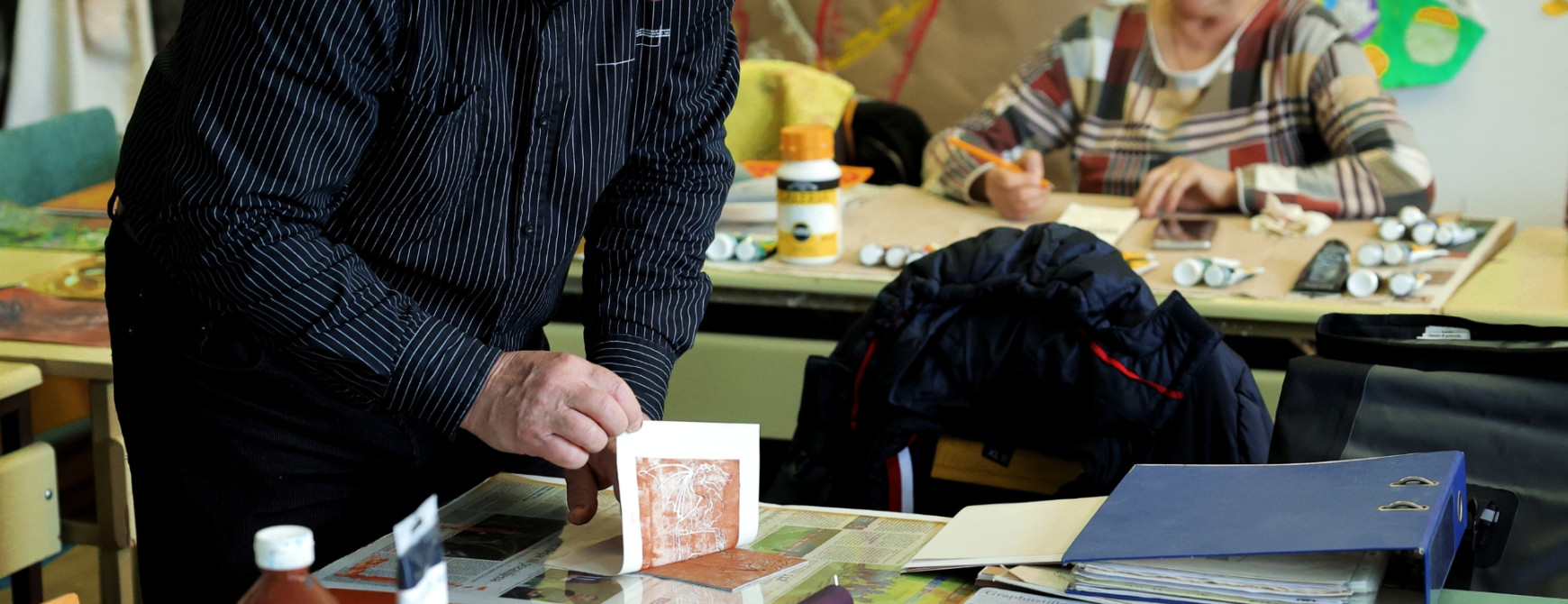 Starejši moški in ženska, ki ustvarjata likovne umetnine.