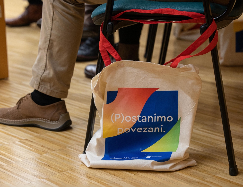 Tekstilna torba z napisom Postanimo povezani.